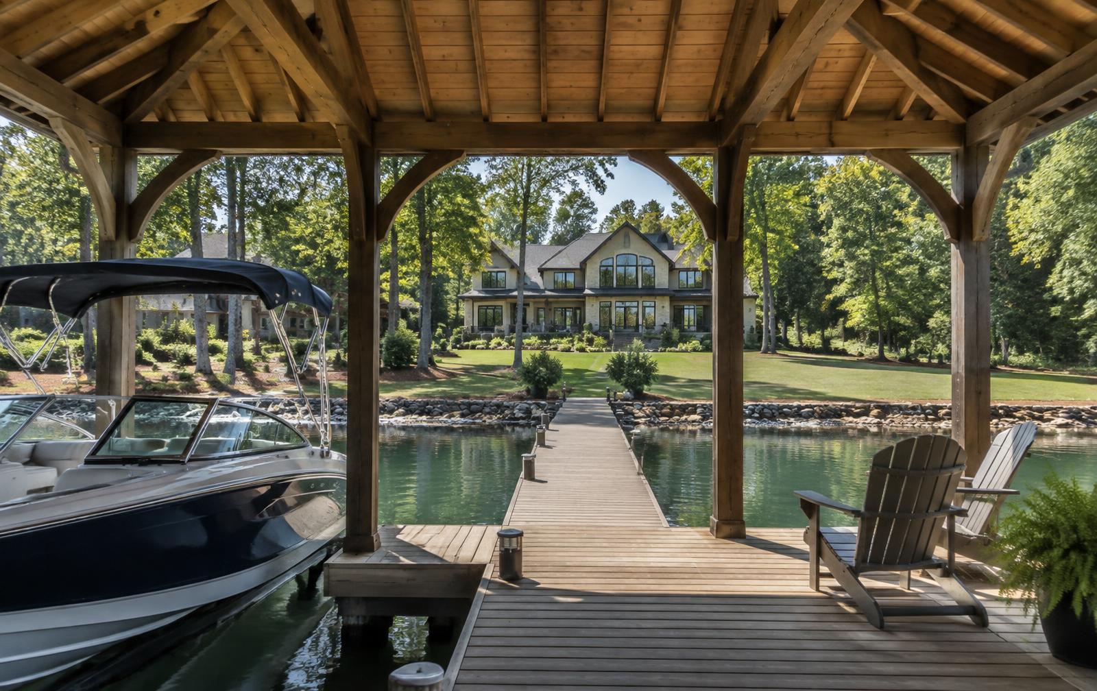 View from beneath a covered boat dock across a wooden walkway toward a Lake Norman waterfront home